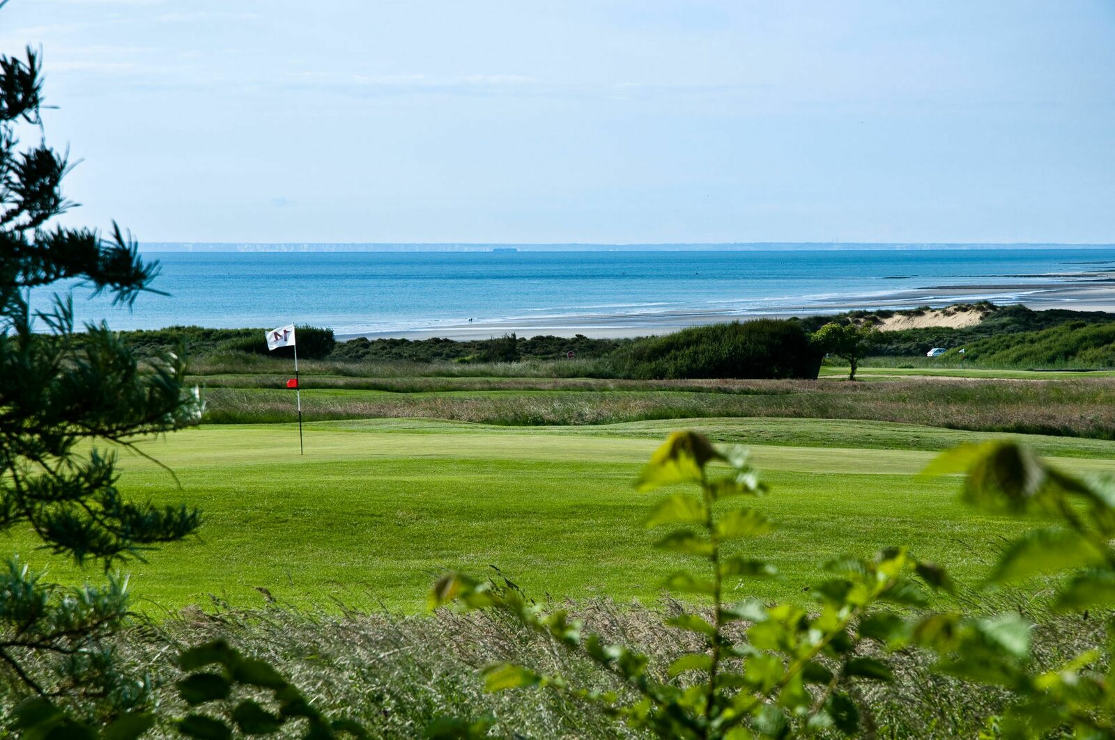 Golfbaan Golf de Wimereux op een zonnige dag met de Opaalkust in de achtergrond. 