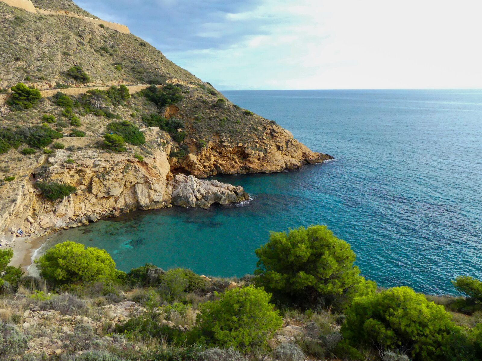 Uitzicht op de prachtige baai van Cala Tio Ximo en de rotsachtige kust 