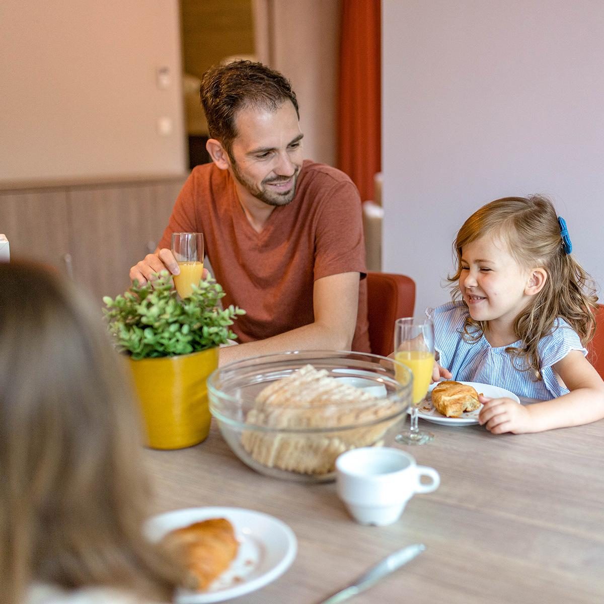 Een gezin aan het ontbijten bij Holiday Suites