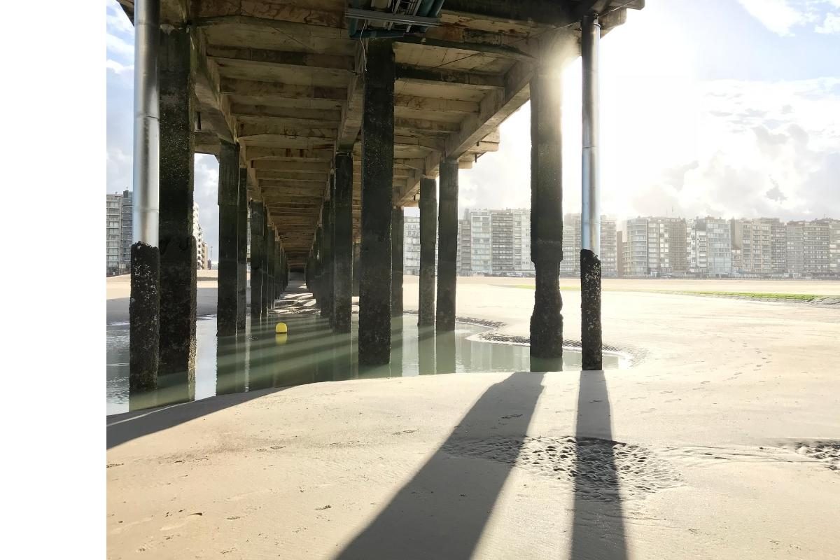 Het strand van Blankenberge onder de wandelweg van de pier