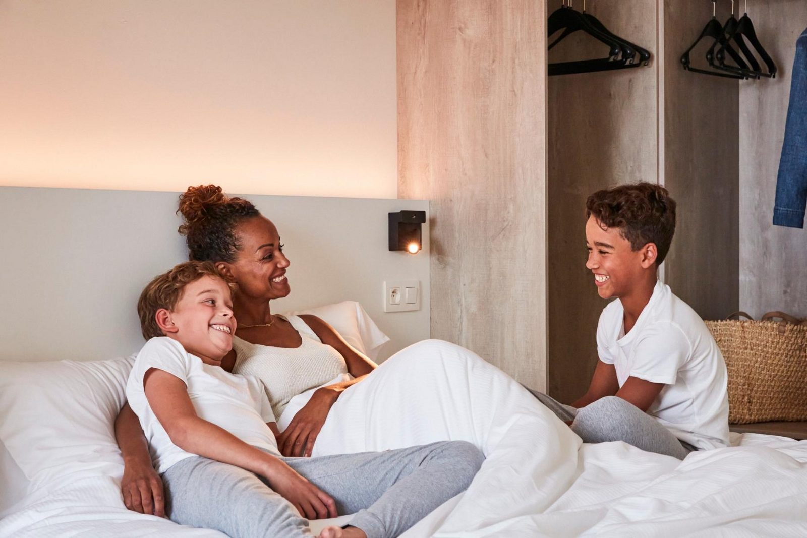 Mama met haar kindjes in bed bij Holiday Suites