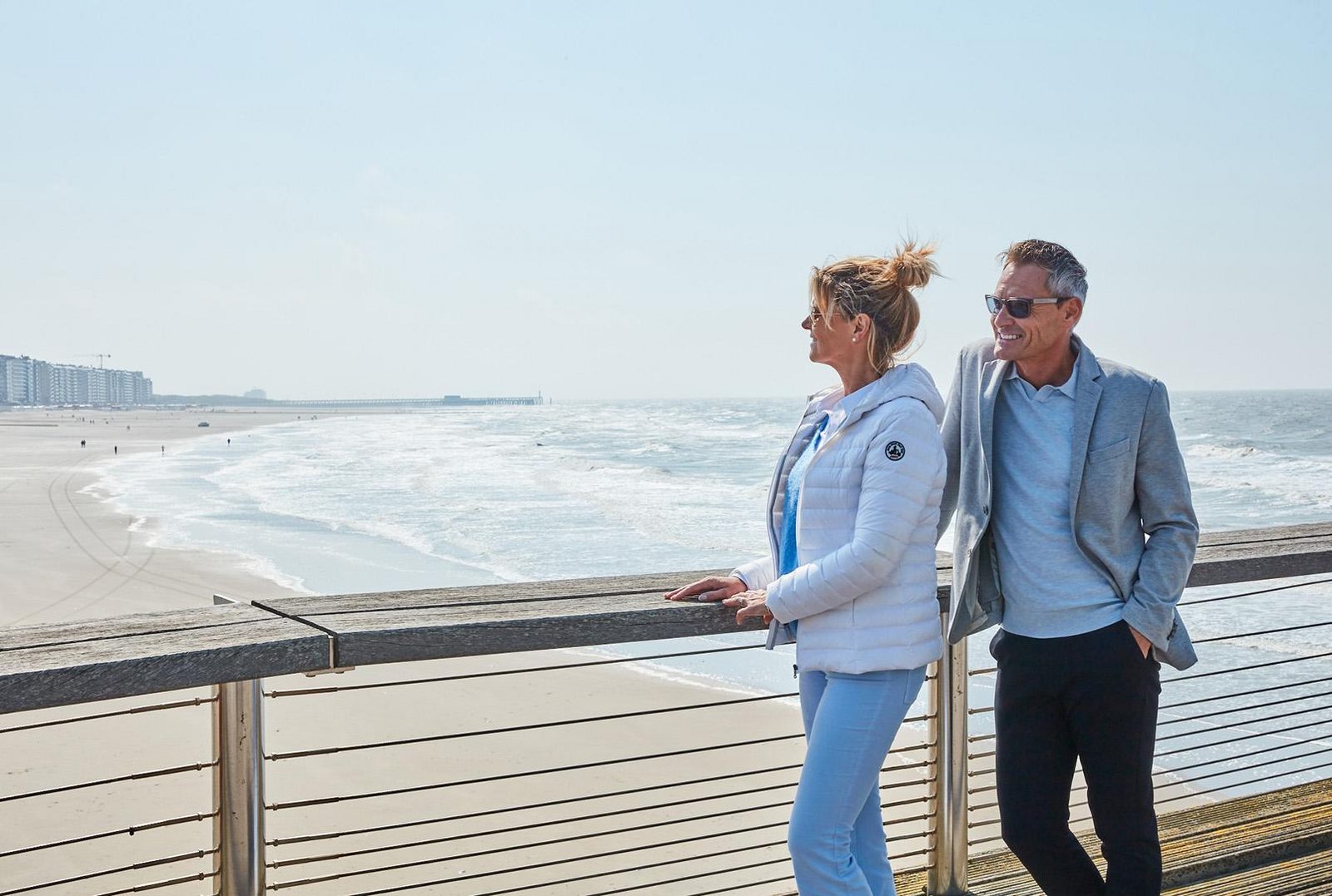 Een koppel op de pier van Blankenberge met de zee en het strand op de achtergrond