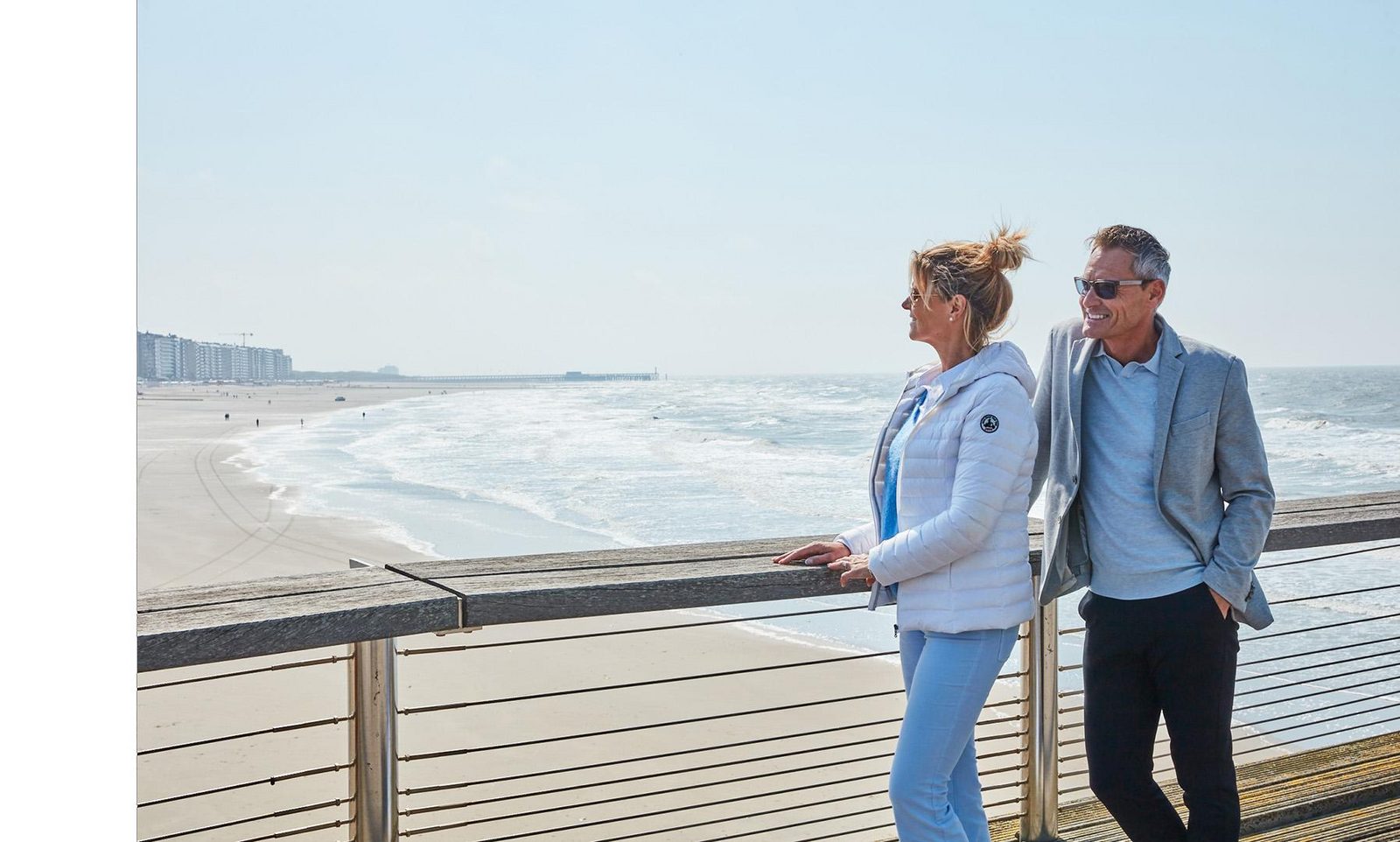 Een koppel op de pier van Blankenberge met de zee en het strand op de achtergrond