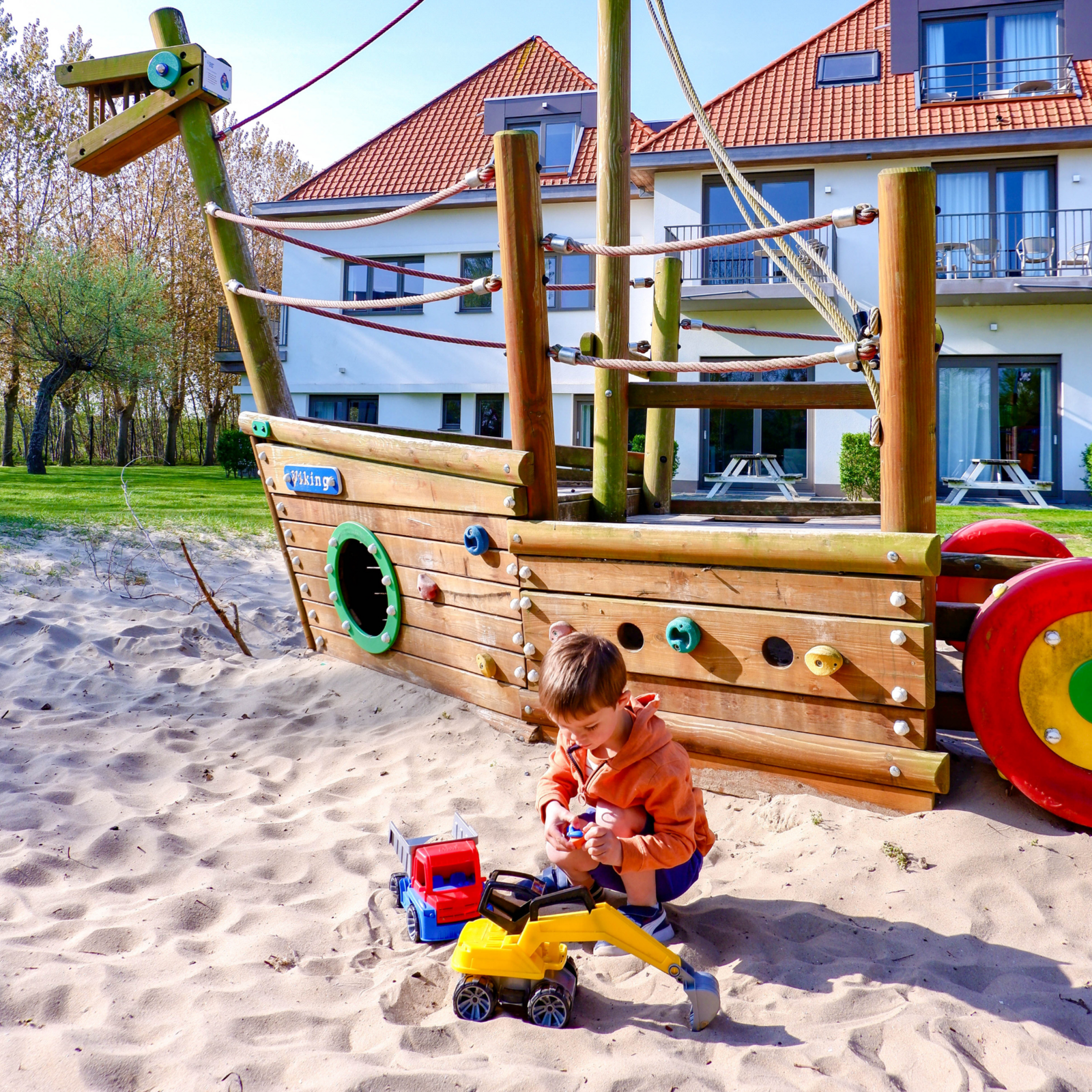 Twee jongens die met een strandbal spelen in het buitenzwembad bij Holiday Suites Zeebrugge