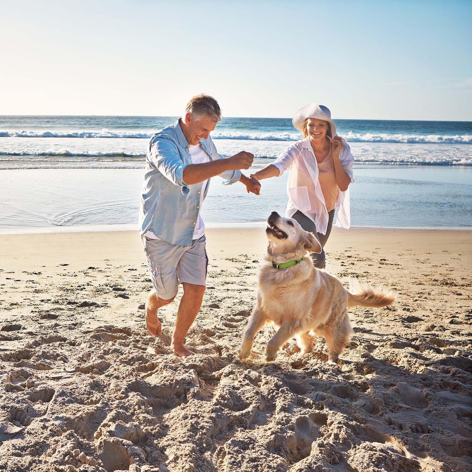 Een koppel met hun hond op het strand