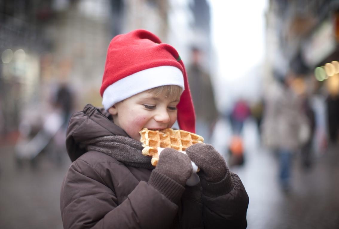 Een jonge die een wafel is aan het eten tijdens de warmste week.