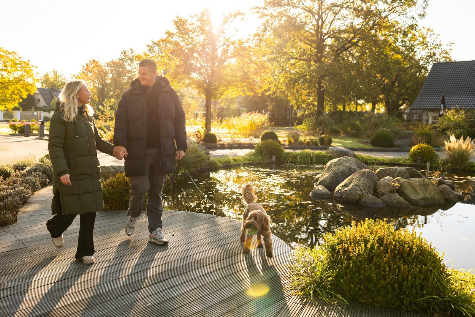 Junges Paar geht mit Hund in herbstlicher Kulisse des Hof van Salland spazieren