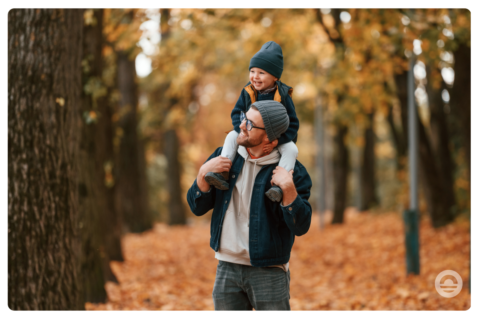 Father walks with child in forest during fall break