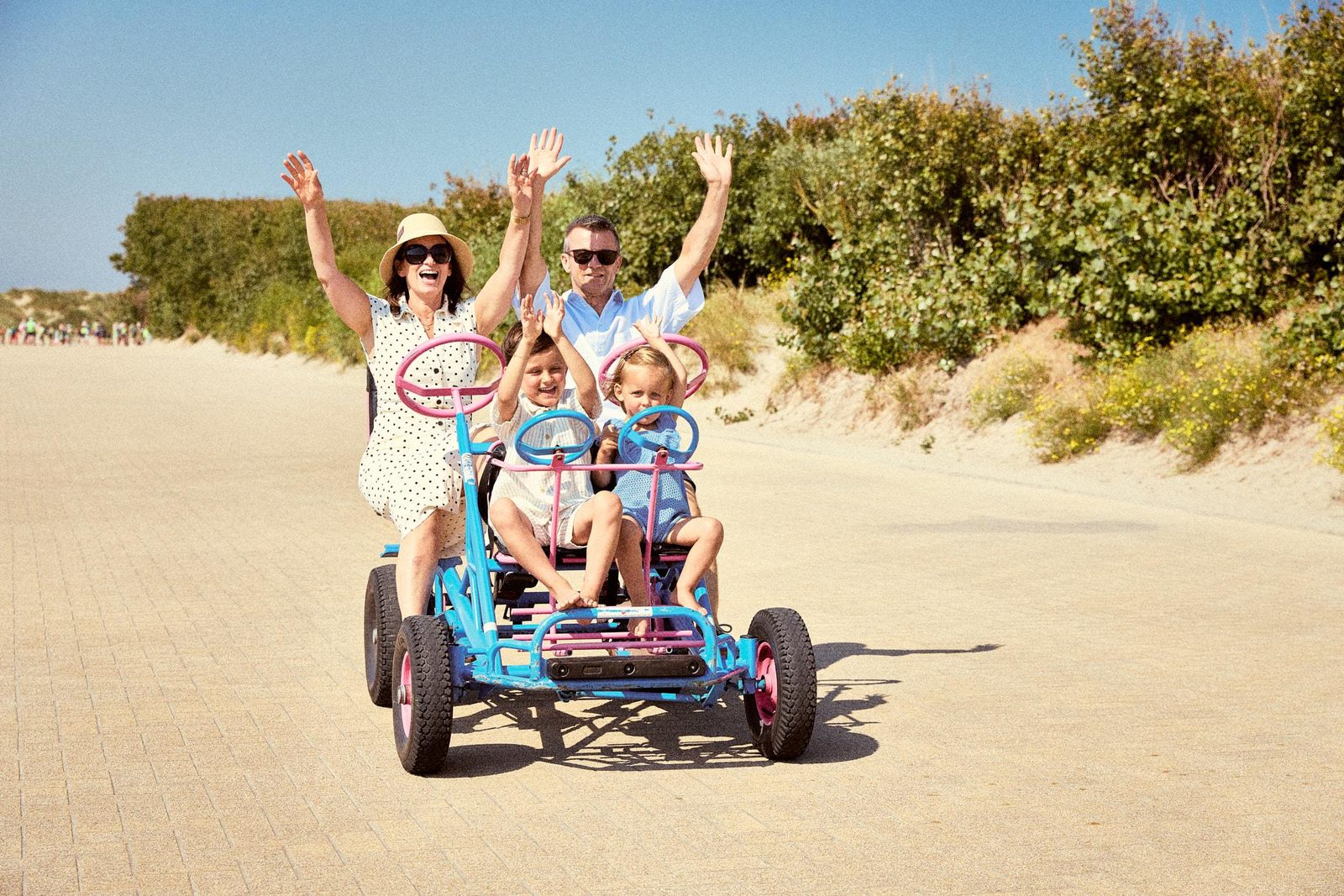 Een familie die op de dijk van Westende met een go-kart rijdt. 