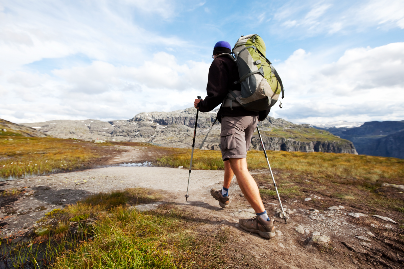 Wandelaar met wandelstokken die aan het lopen is.