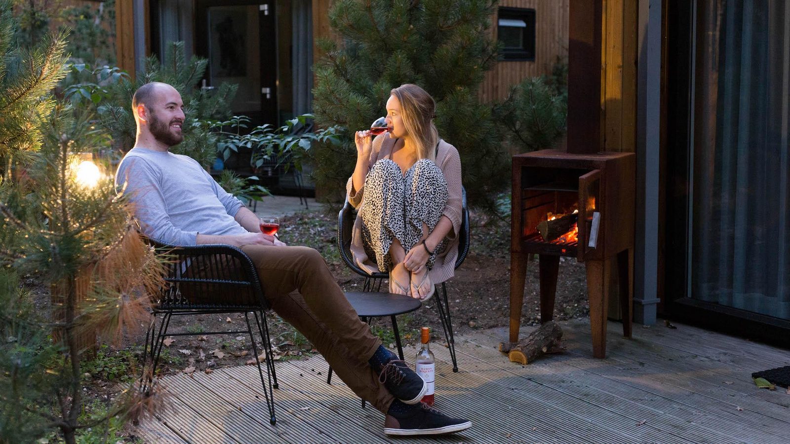 Wijn drinken bij de houtkachel voor een Tiny House EuroParcs Maasduinen