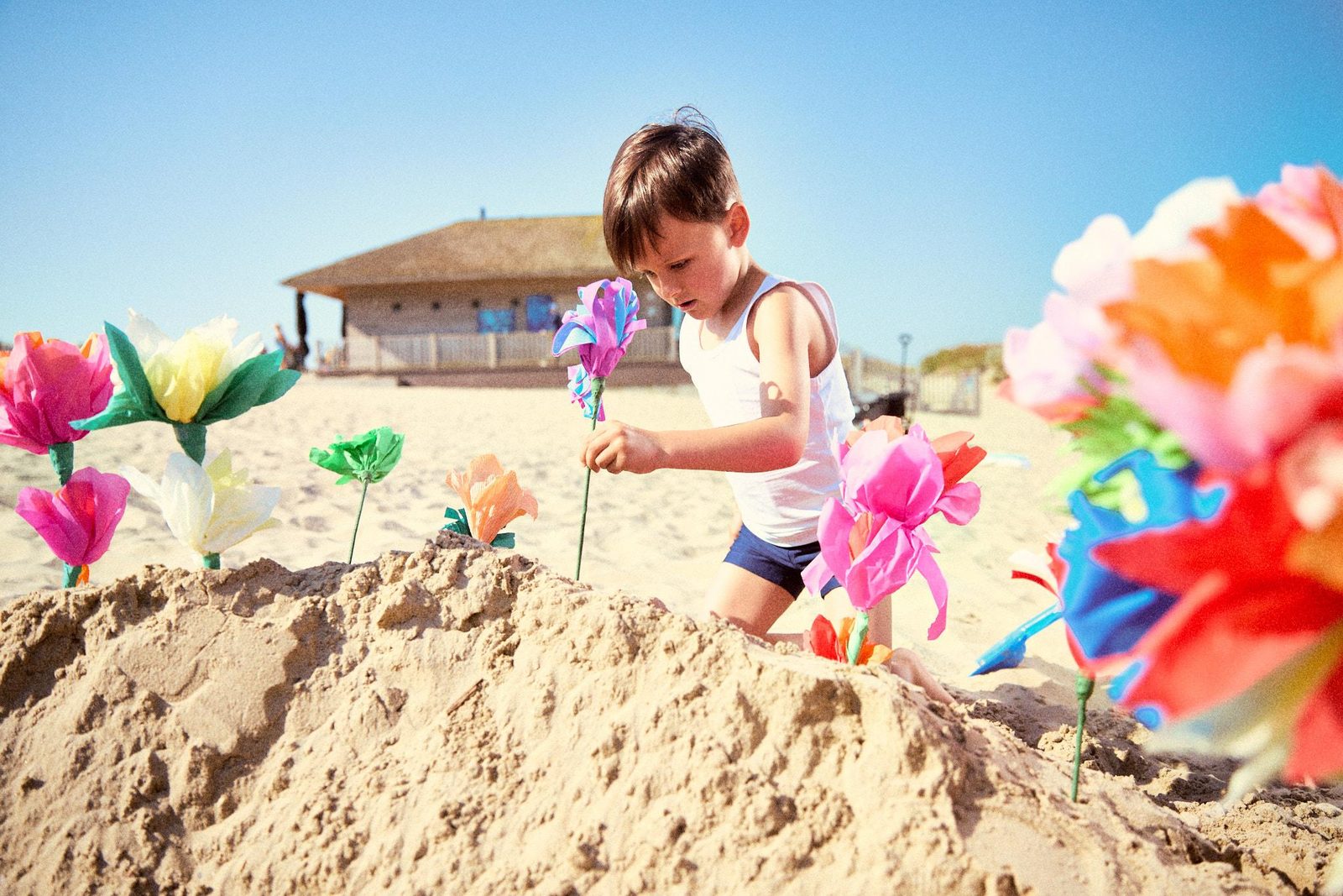 jongen op het strand met zelfgemaakt bloemen