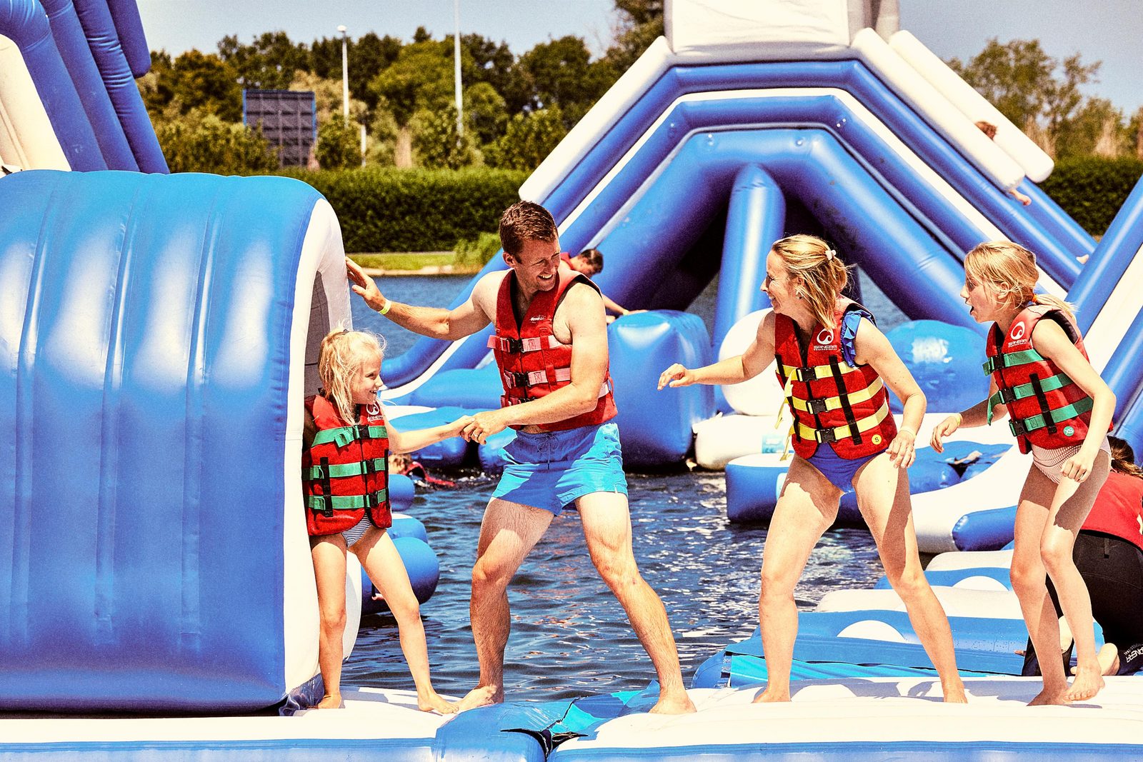 Afbeelding van een familie die op het opblaasbaar aquapark in Jabbeke speelt.