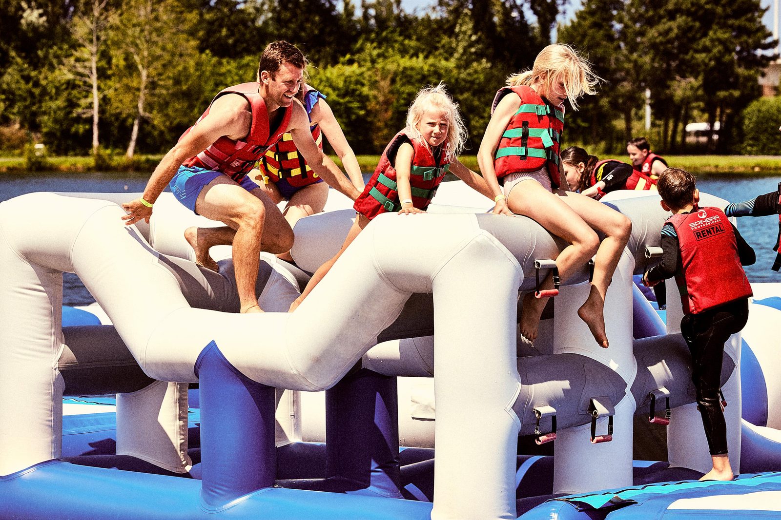 Afbeelding van een familie die op het opblaasbaar aquapark in Jabbeke speelt.