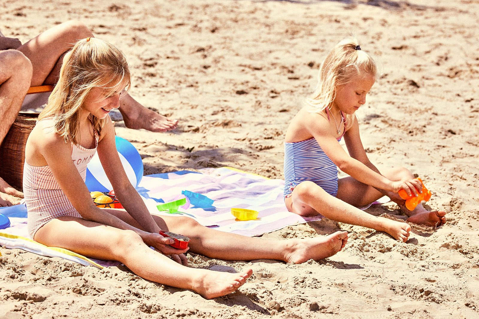 Afbeelding van een familie die op het strand van Jabbeke Klein Strand speelt.