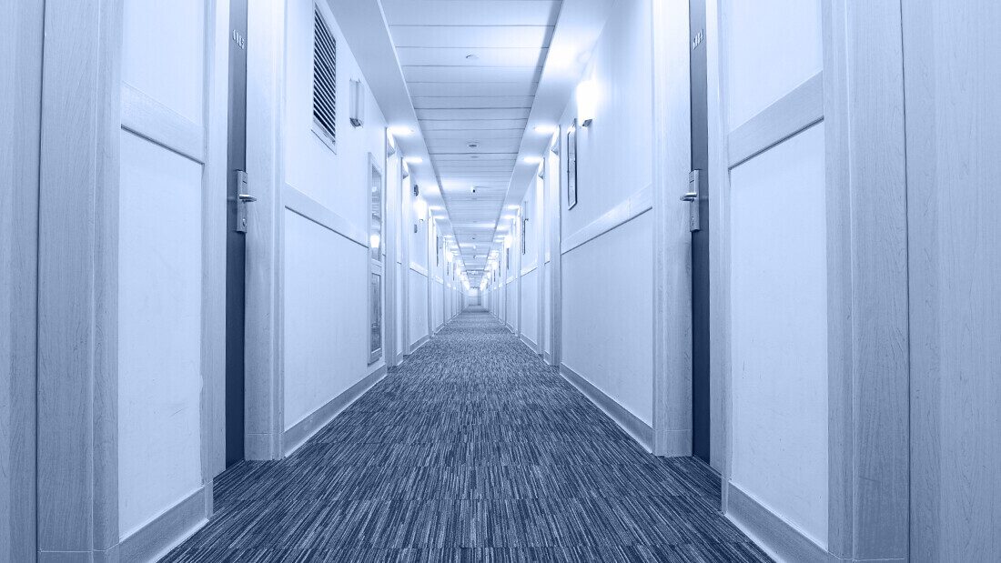 Budget hotels provide a much more clinical experience Corridor of a budget hotel or holiday park accommodation with doors leading to guest rooms.