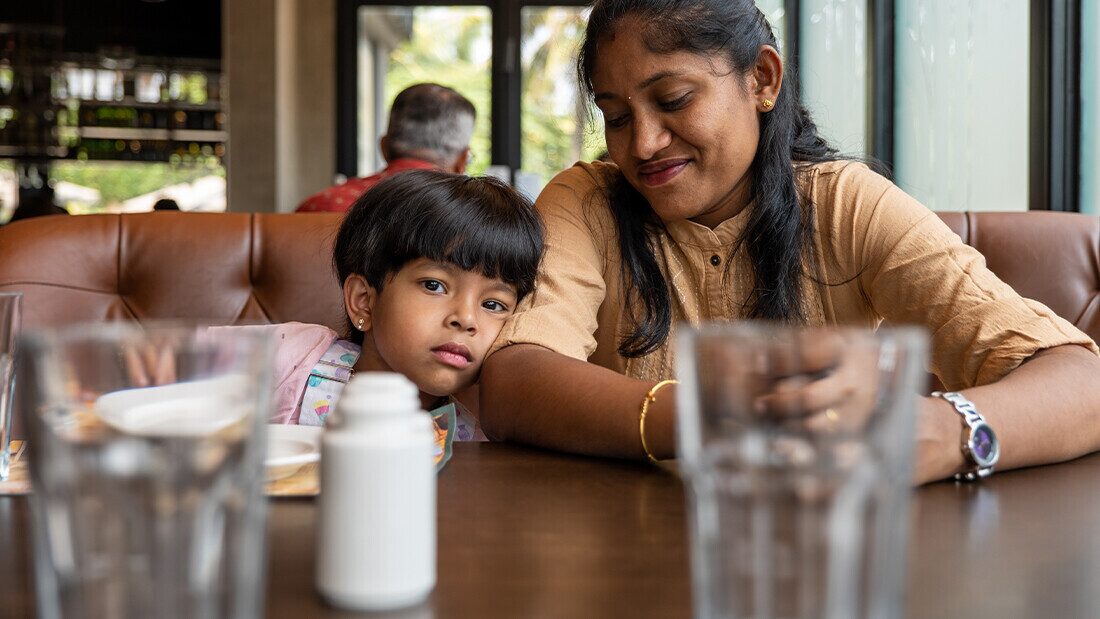 Budget hotels may be limited to a bar serving many visitors Mother and child sitting together at a restaurant table in a family-friendly holiday hotel in Devon