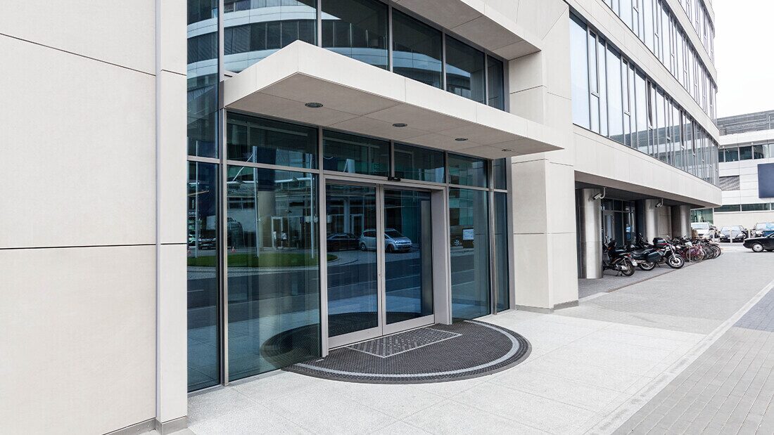 Budget hotels are rarely in scenic locations for holidays Exterior entrance of a modern budget chain hotel with glass doors and parking area.