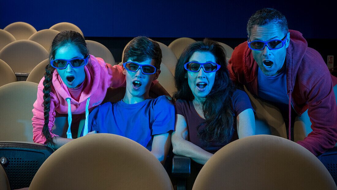 Family enjoying a 3D cinema experience together at a holiday park entertainment venue.
