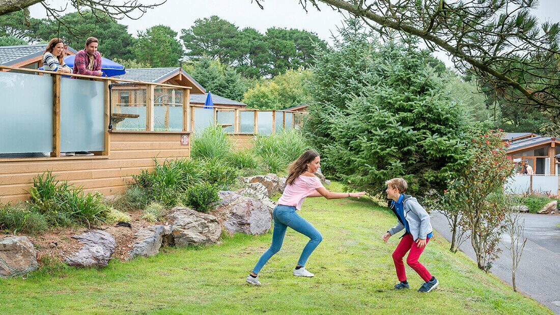 Family enjoying time together outside holiday lodges at Woolacombe Bay Holiday Parks.