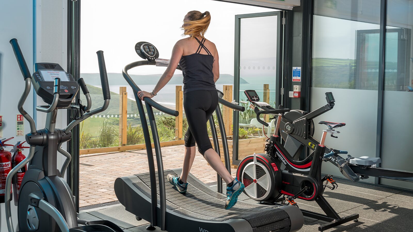 Woman running on the treadmill in the gym at Woolacombe Bay with the sea in view