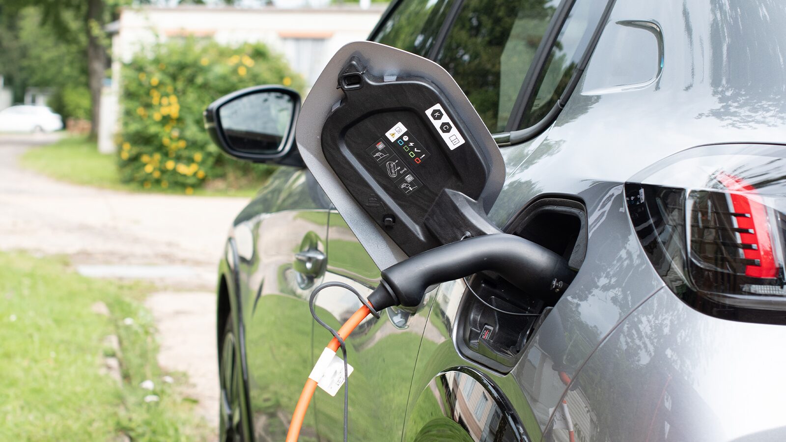 An electric vehicle connected to a charging station on a holiday park, showcasing the process of recharging its battery.