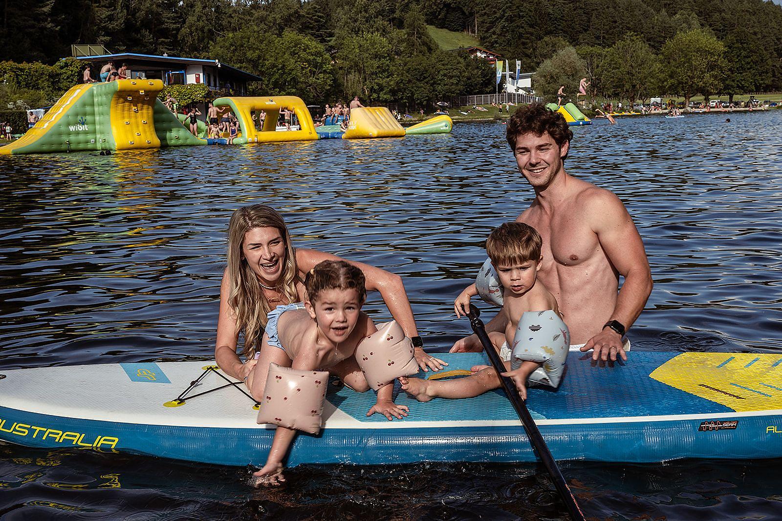 Family on SUP at Lake Natterer See in Tyrol, swimming and splashing