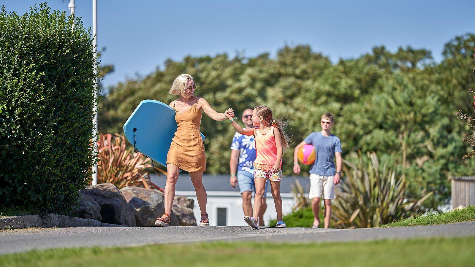 A woman and daughter walking hand in hand at Beach Haven holiday park area at Twitchen House in Woolacombe, Devon.