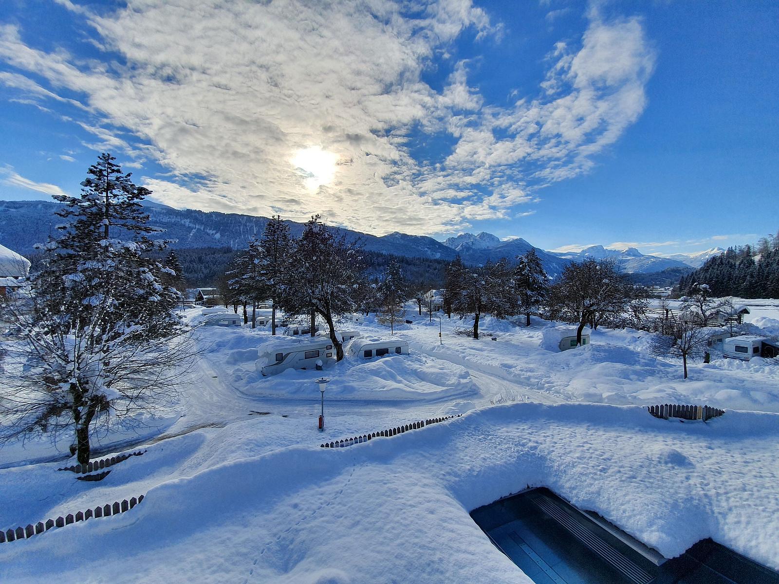 Schneebedeckter Wintercampingplatz mit Bergen 