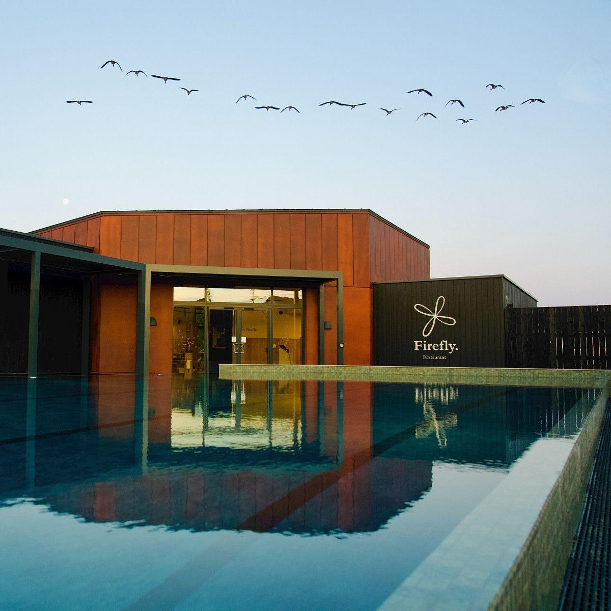 Firefly Restaurant at Silverlake Estate, Dorset, reflected in Firefly Spa's 25m heated outdoor pool, with birds flying overhead in the evening sky. Firefly Restaurant at Silverlake Estate, Dorset, reflected in Firefly Spa's 25m heated outdoor pool, with birds flying overhead in the evening sky.