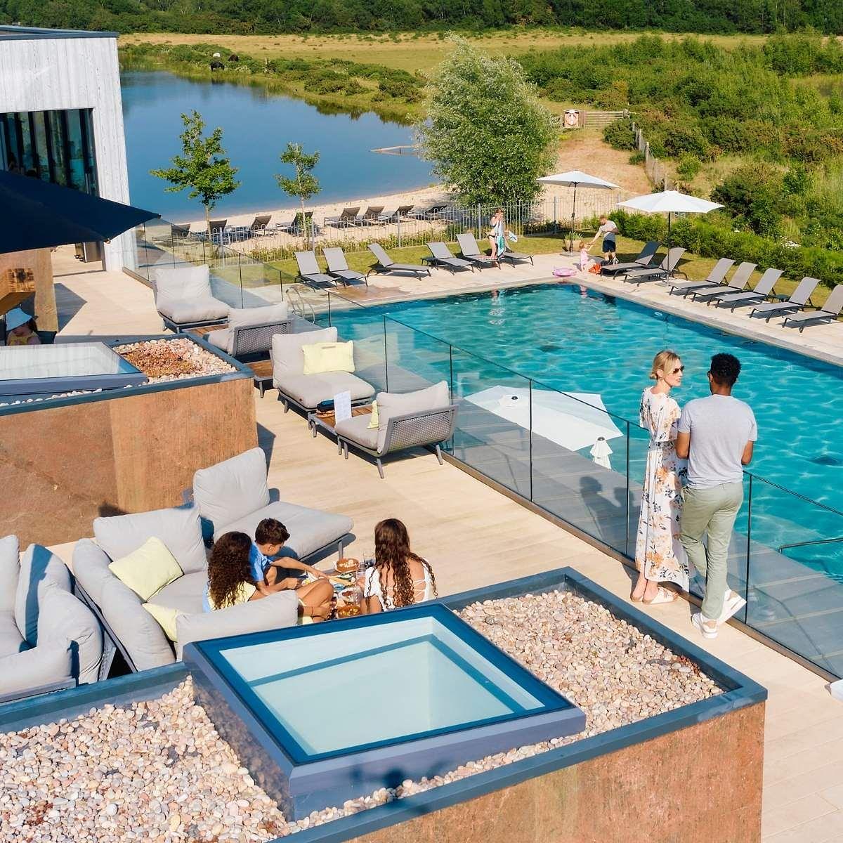 Homeowner-only Hurricane Terrace at Silverlake Estate, featuring luxury outdoor seating beside an infinity-style pool with views across lakes and nature reserves in Dorset.