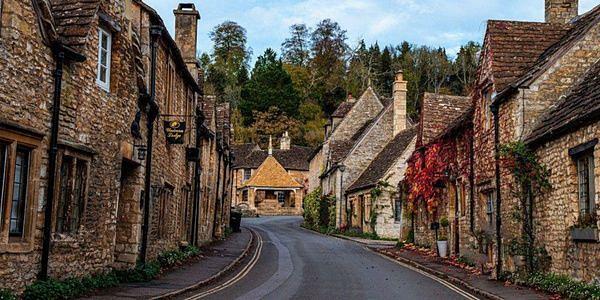 Traditional stone cottages lining a winding street in Castle Combe, a picturesque village in the Cotswolds