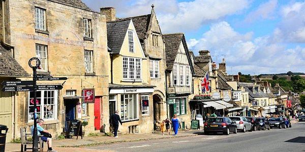 Historic stone buildings and independent shops lining Burford's high street in the Cotswolds