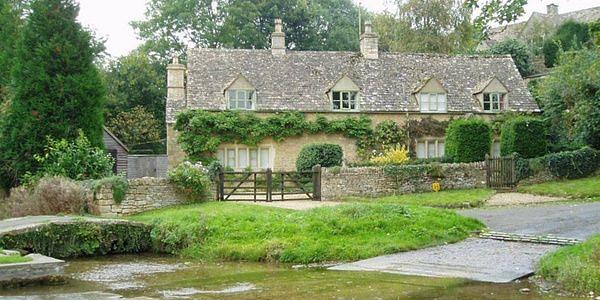 Traditional stone cottage and ford crossing in Upper Slaughter, a peaceful village in the Cotswolds