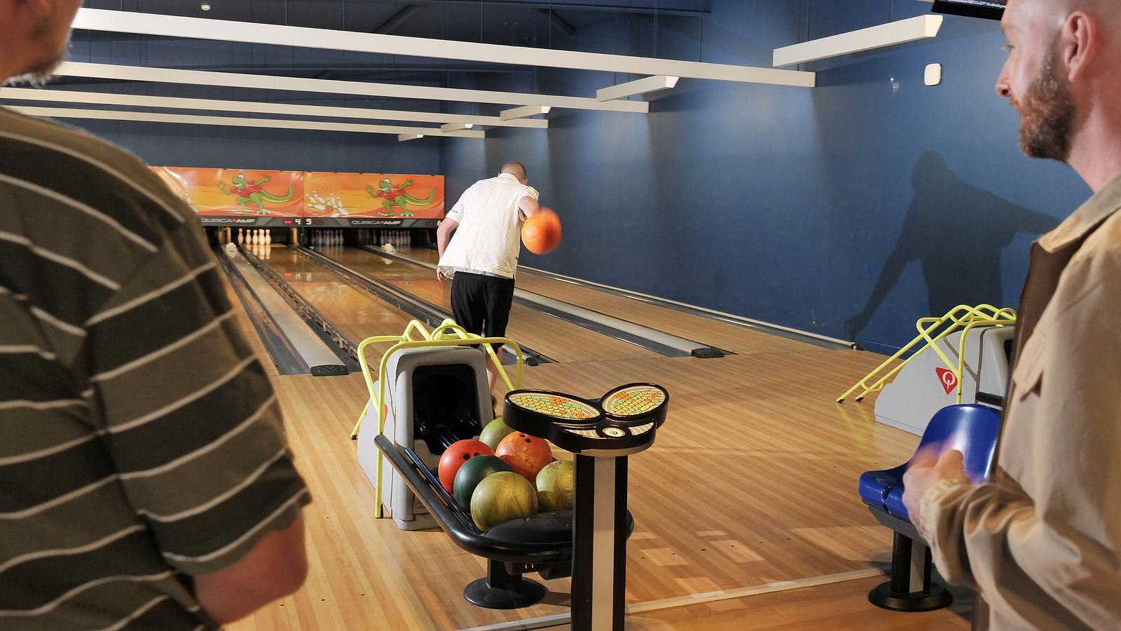 Group of corporate colleagues celebrating a strike on the 6-lane 10-pin bowling alley at Jurassic Fun Centre