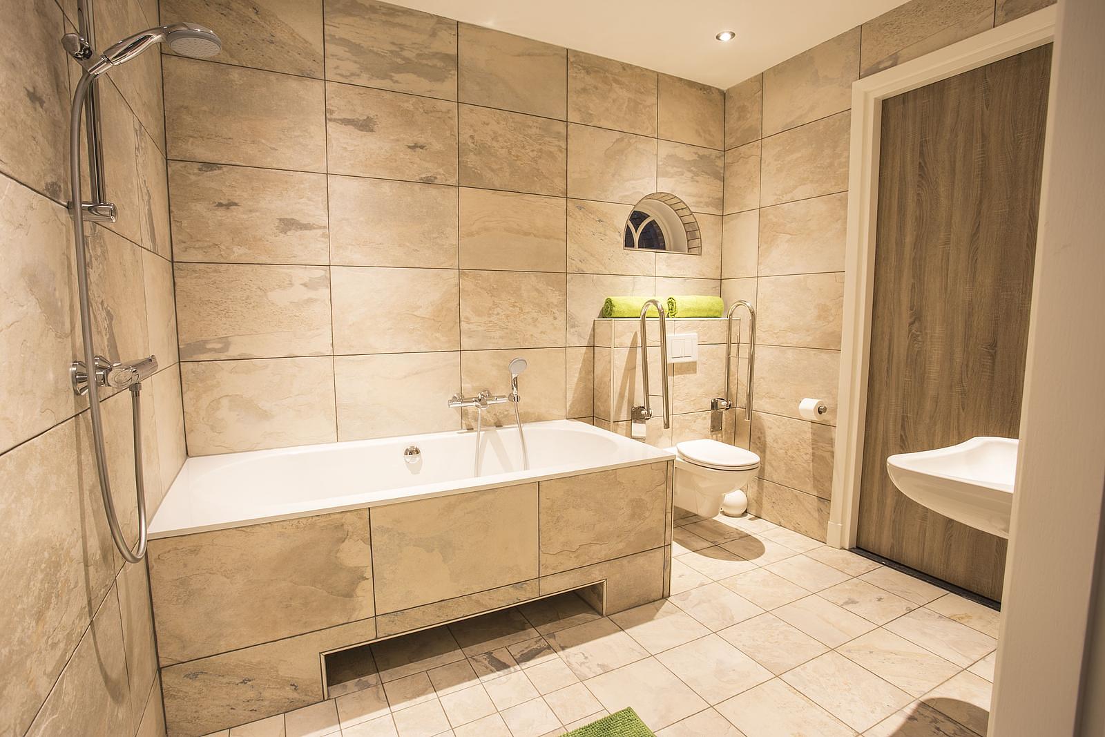 Bathroom with a bathtub and shower in De Sterre