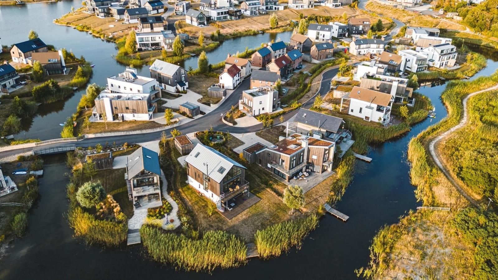 Aerial view of contemporary holiday homes surrounded by lakes and nature trails at Silverlake Estate in Dorset.